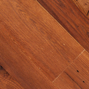 A close-up view of Cinnamon Toast floorboards reveals a rich, warm cinnamon brown hue with visible grain patterns. Some boards feature minor scratches and imperfections, enhancing their well-toasted charm.