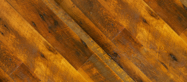 Close-up of Natural wooden planks displaying a warm brown tone. The texture highlights visible grain patterns and small knots, arranged diagonally for an appealing geometric design.