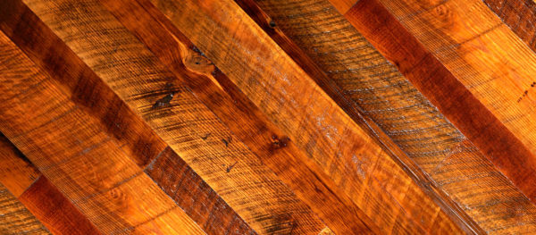 Close-up of Rustic Heart Pine showcasing diagonal planks in diverse brown shades, highlighting its textured wood with visible grain and natural imperfections for a warm, earthy look.