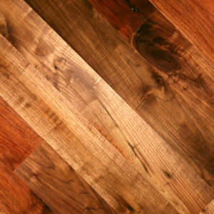 A close-up of the Antique Walnut floor reveals a herringbone pattern in shades of brown, with natural grain and knots for a warm, rustic look.