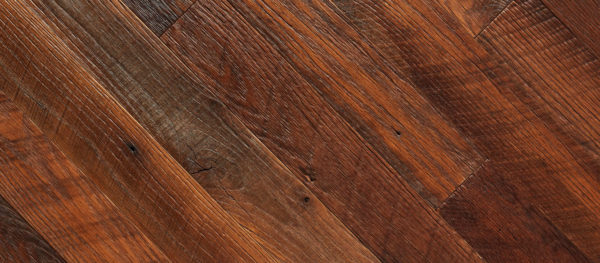 Close-up view of Summer Beam planks arranged diagonally, highlighting their natural grain patterns and diverse shades of brown for a rustic texture.