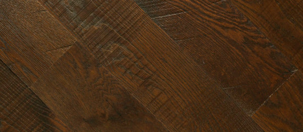 The Malted Barley wooden floor showcases a dark brown herringbone pattern, rich in texture and grain. Its polished finish highlights the natural wood details, offering a warm and elegant look.