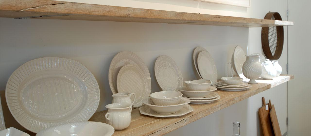 Floating reclaimed wood shelves displaying plates and dining wares.