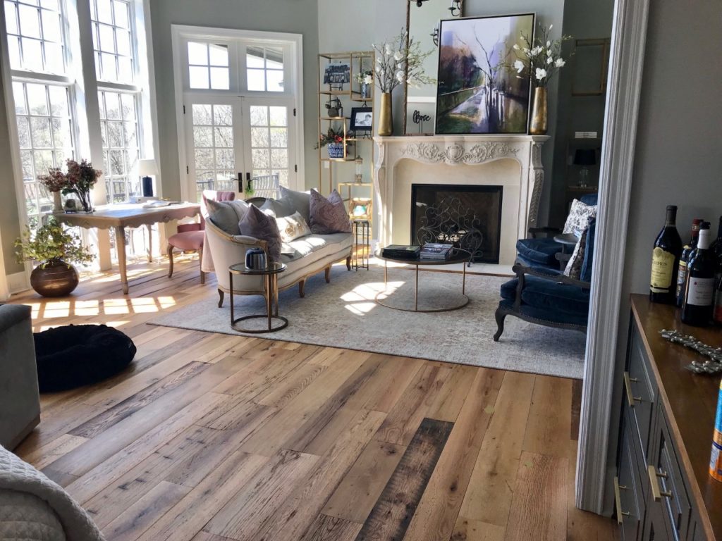 A spacious, sunlit room boasts sustainable hardwood flooring.