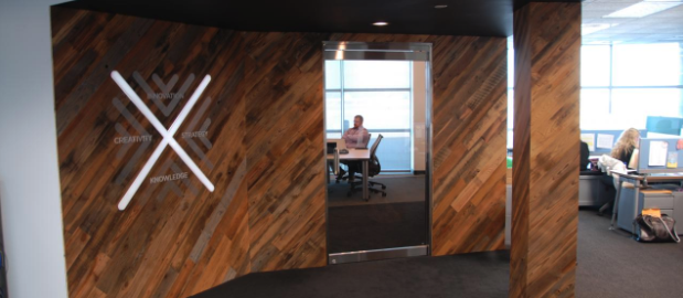 Wood accent wall matches the same wood panels on a nearby column in an office environment.
