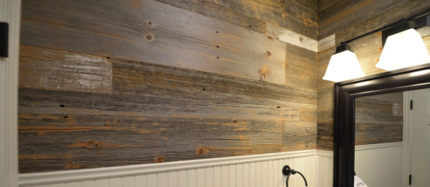 Rustic barn wood planks installed above white wainscoting in a bathroom.