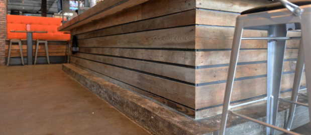 Barn wood wall panels are used to cover the lower, front portion of bar.
