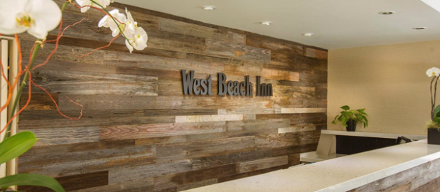 Barn wood accent wall behind the front desk of a hotel.