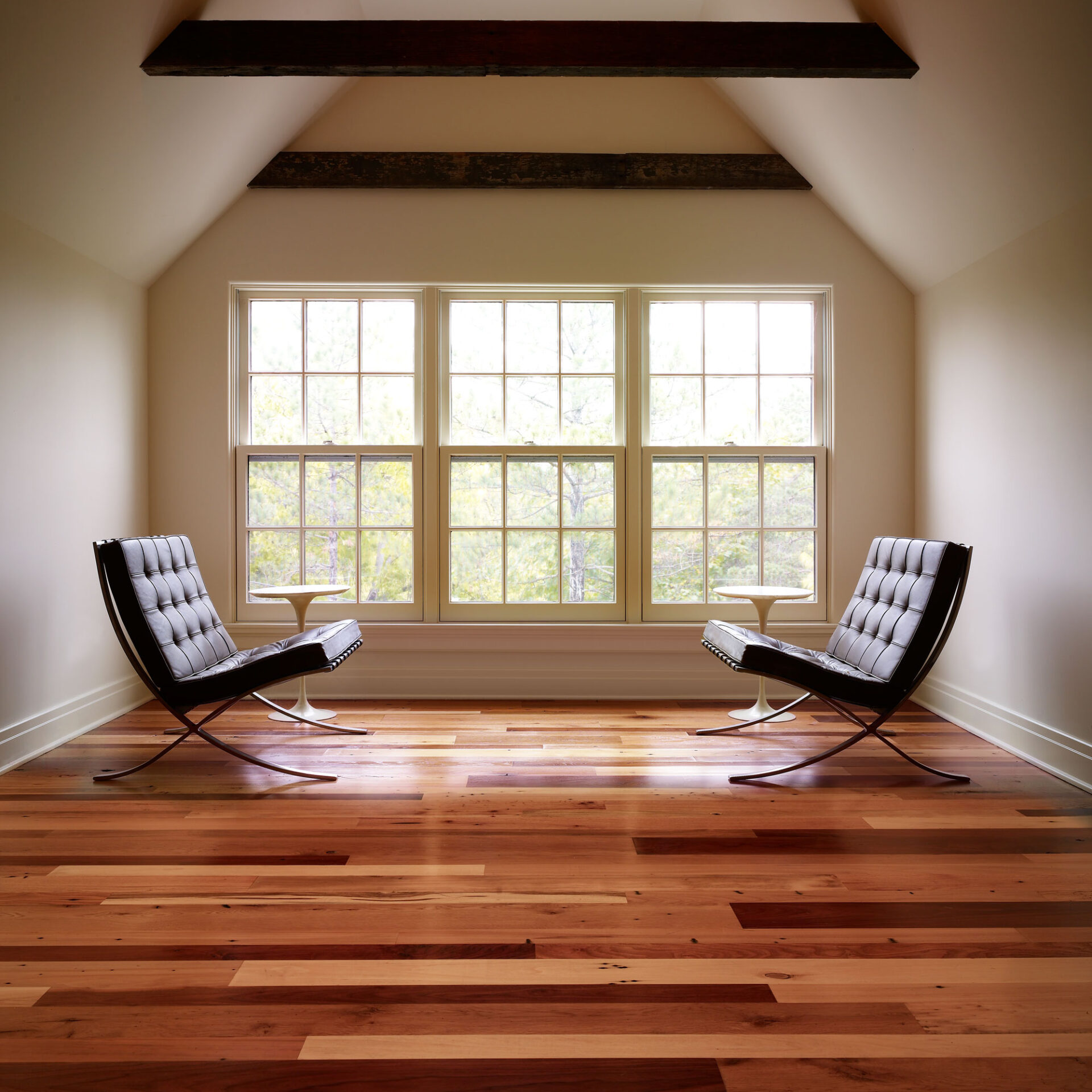 A window nook with two chairs and mixed wood wide plank flooring