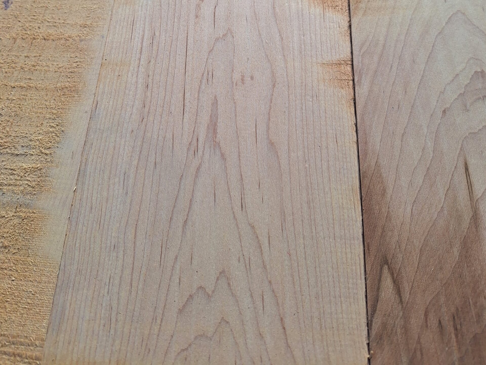 Close-up of two wooden boards side by side with visible natural grain patterns. Perfect for our inventory specials, the left board has a slightly rough texture, while the right one appears smoother and darker.