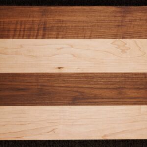 The 24 x 18 Custom Cutting Board features alternating horizontal stripes of light maple and dark walnut for a stylish, symmetrical look—adding both elegance and function to any kitchen.