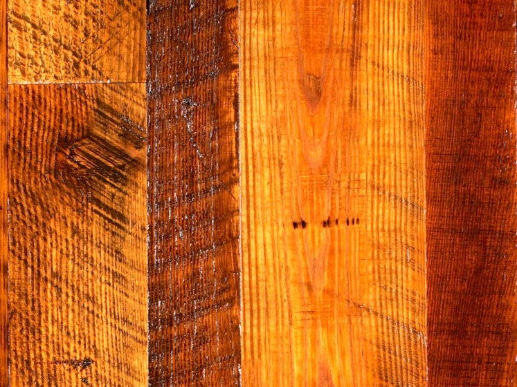 Close-up of milled heart pine wood for sale, showcasing floor planks with rich brown shades and visible wood grain texture.
